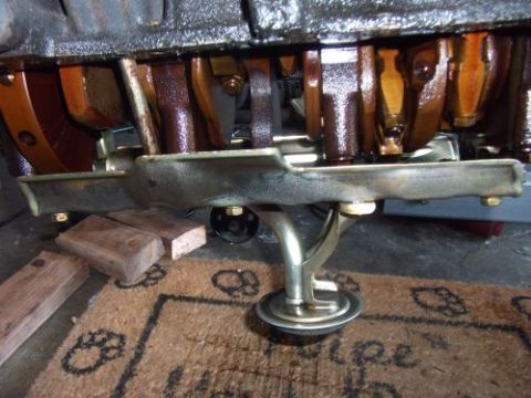 1991 Ford Taurus - Close-up view of an engine's oil pan and crankshaft, supported by wooden blocks.