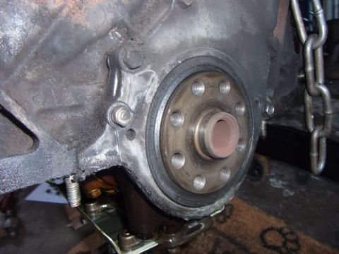 1991 Ford Taurus - Close-up view of an engine block showing the crankshaft seal and surrounding components, with a metal chain in the background.