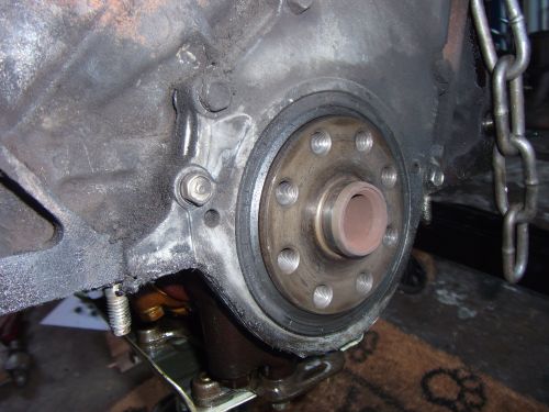Engine block with crankshaft seal and mounting bolts. Chain visible