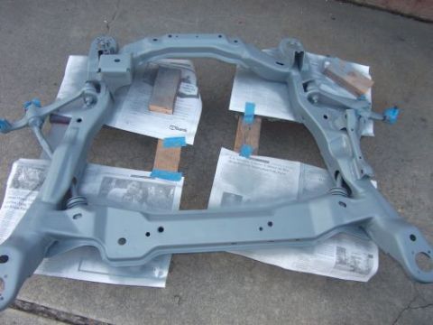 1991 Ford Taurus - A gray front subframe, likely for an engine swap, is shown after being painted and placed on newspapers for drying.