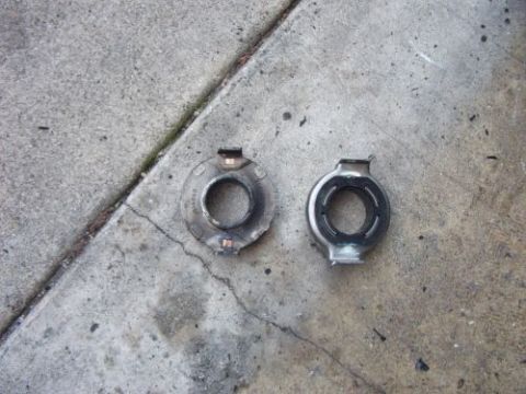 1991 Ford Taurus - Two headlight retaining rings are shown on a concrete surface.