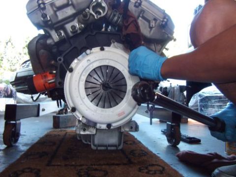 1991 Ford Taurus - Mechanic works on an engine and clutch assembly, likely during an engine swap.