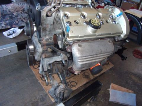 1991 Ford Taurus - A Ford V6 engine is shown, possibly for an engine swap, with its valve covers and exhaust components visible.
