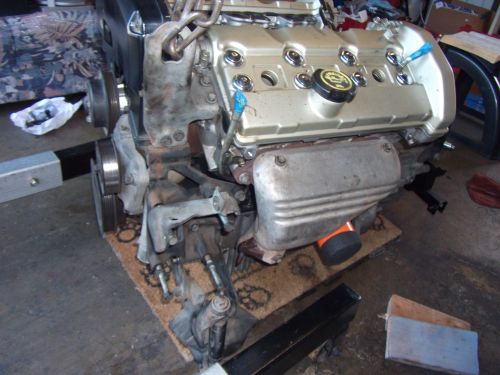 Engine on a stand, gold valve covers, exhaust manifold visible