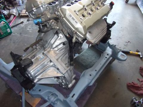 1991 Ford Taurus - Engine and transmission assembly, possibly for an engine swap, with part number XA 950 AA visible on the valve cover.