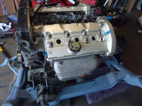 1991 Ford Taurus - This engine assembly is on a stand, ready for installation or work. The oil cap is visible on the valve cover.