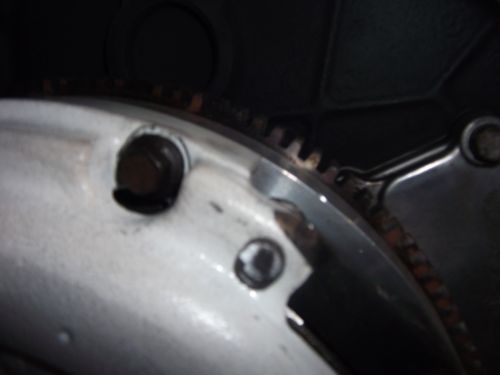 Close-up of engine part with visible gear teeth and bolts