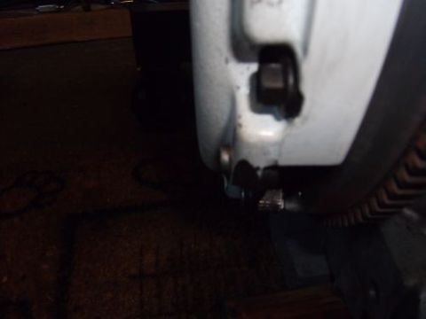 1991 Ford Taurus - A close-up view of a bolt and a ribbed belt on a vehicle's engine component.