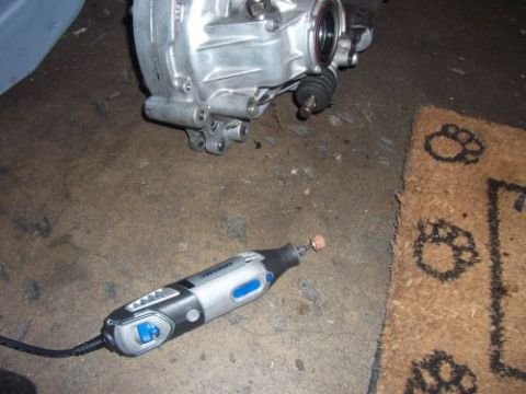 1991 Ford Taurus - A car's differential and a rotary tool are on the floor, with a doormat paw prints nearby.