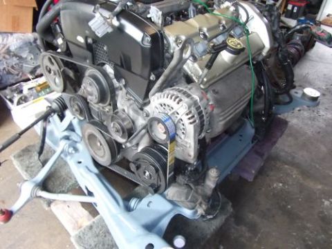 1991 Ford Taurus - Engine assembly with various components visible, mounted on a stand for display or work.