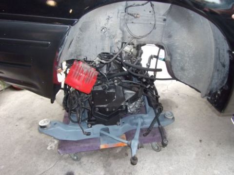 1991 Ford Taurus - Engine removed from vehicle, resting on a dolly, with Supermotors.net watermark.