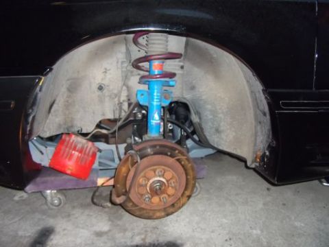 1991 Ford Taurus - Close-up of a car's front wheel assembly, showing the shock, brake, and inner fender liner.