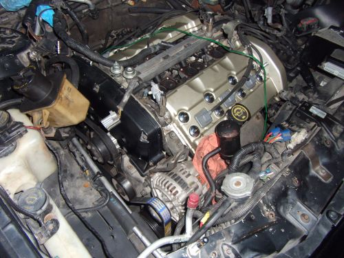 Engine bay with gold valve covers and visible alternator. SuperMotors logo at bottom right