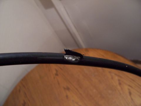 1978 Ford F-150 - A close-up view of a damaged black cable with exposed wiring and metal.