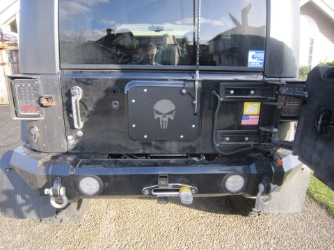2008 Jeep Wrangler - The rear of a black Jeep Wrangler shows a custom bumper with a winch and a Punisher skull decal.