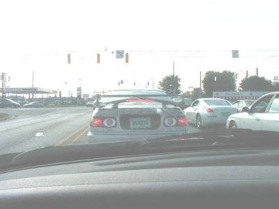 1997 Ford Taurus - Washed-out shot taken through a windshield from the driver's seat, showing the rear of a dark green Toyota Supra stopped at a signalized in…