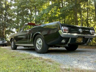 1965 Ford Mustang - Rear view of a black 1965 Ford Mustang convertible parked outdoors.