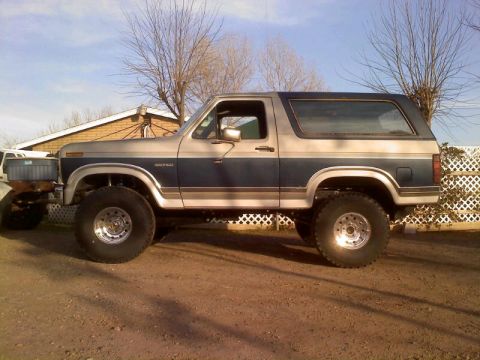 1986 Ford Bronco - This lifted 1986 Ford Bronco features a two-tone paint scheme and appears to be modified for off-road use.