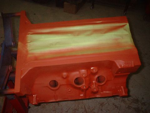 1969 Mercury Cyclone - An engine block is being painted orange, with masking tape applied to protect certain areas.