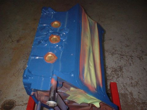 1969 Mercury Cyclone - Engine block painted blue with colorful spray paint streaks, resting on a stand.