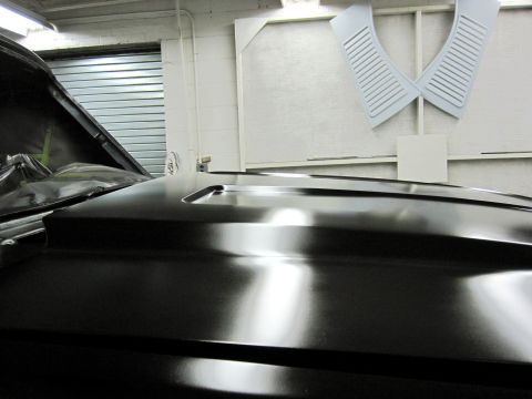 1992 Ford Bronco - Close-up of a car hood with a scoop, possibly undergoing restoration or painting.