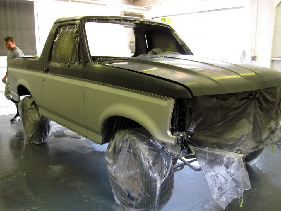 1992 Ford Bronco with plastic sheeting on wheels and front end, ready for paint
