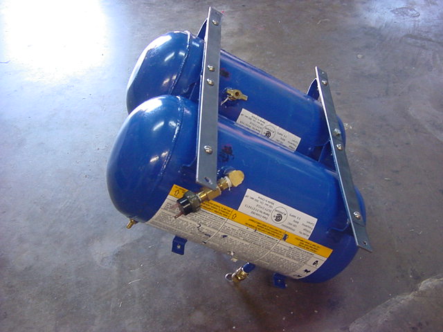 Dual blue air tanks with steel bracket and brass valves on concrete floor