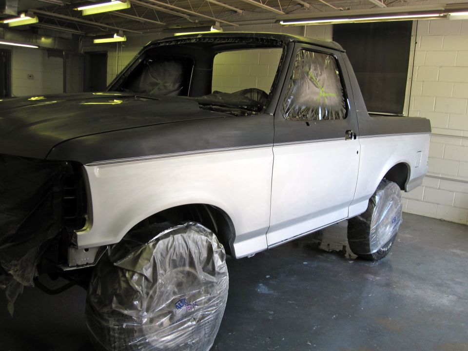 1992 Ford Bronco in a paint booth, two-tone gray and white