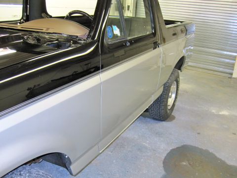 1992 Ford Bronco - The side profile of a two-tone Ford Bronco, showing its distinctive body style and wheels.