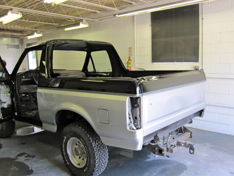 1992 Ford Bronco - This 1992 Ford Bronco is undergoing work in a garage, showing its two-tone paint and exposed interior.