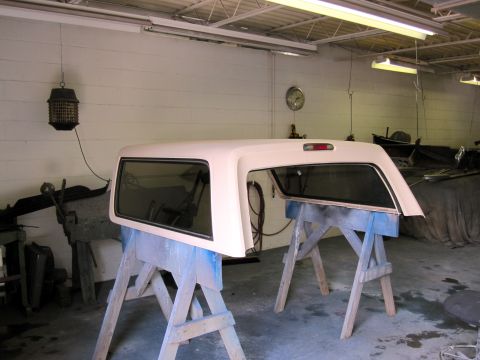1992 Ford Bronco - Truck cap on sawhorses in a garage, possibly undergoing restoration or repair.