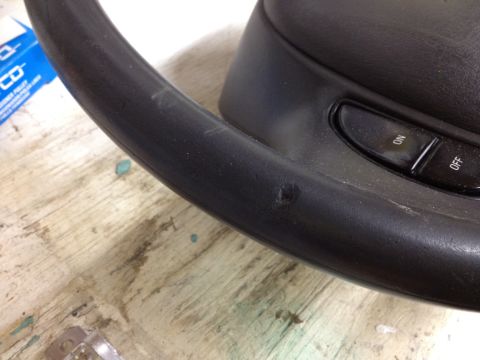 1998 Ford Crown Victoria - Close-up of a worn steering wheel interior, with visible damage and control buttons.