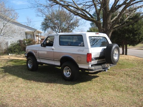 1994 Ford Bronco - 1994 Ford Bronco with a spare tire mounted on the rear door, parked on a lawn.