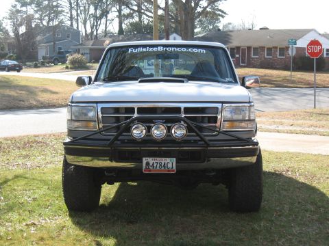 1994 Ford Bronco - White Ford Bronco with "FullsizeBronco.com" on windshield. Front view with aftermarket bumper.