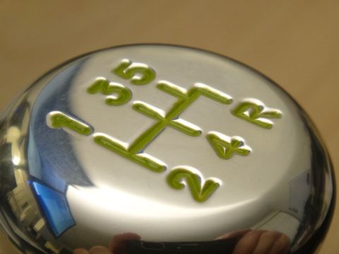 1995 Ford Taurus - A close-up of a chrome shift knob displays the gear pattern for a manual transmission.