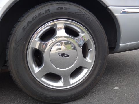 2000 Lincoln Continental - Close-up of a Lincoln Continental wheel and tire, showing the brand emblem and tire details.