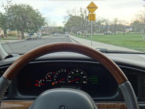 2000 Lincoln Continental - Interior view of a 2000 Lincoln Continental, displaying the dashboard and a suburban street ahead.