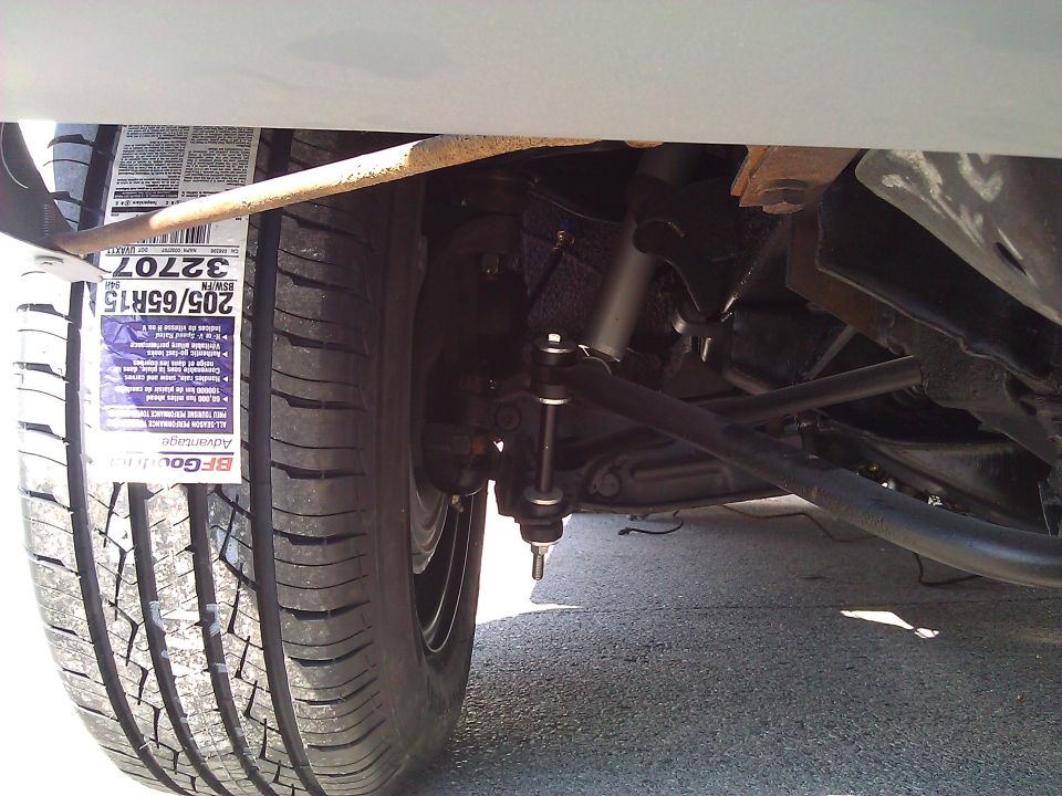 Close-up of car suspension components and a tire with a BFGoodrich Advantage tire tag showing size 205/65R15