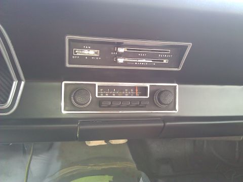 1971 Dodge Dart - Close-up of a car's dashboard, focusing on the climate control panel and the vintage radio unit.