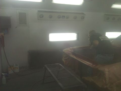 1971 Dodge Dart - A person works on a car interior covered in plastic sheeting within a paint booth.