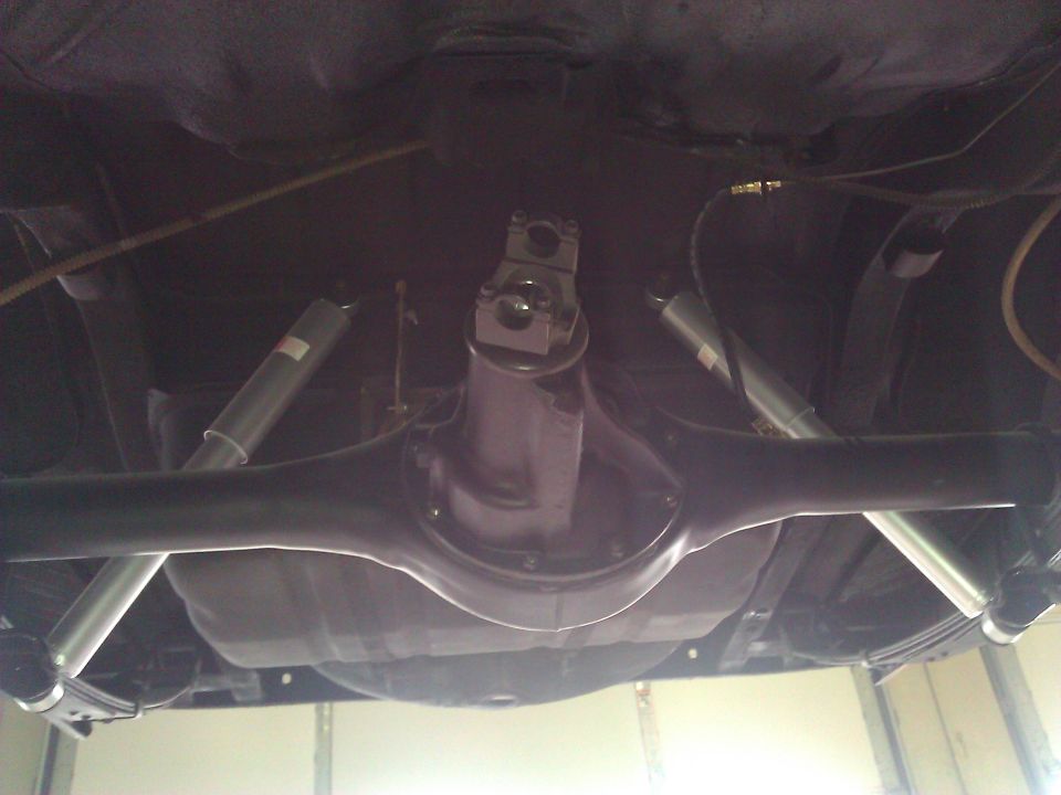 Underside view of a rear axle assembly with shocks and leaf springs