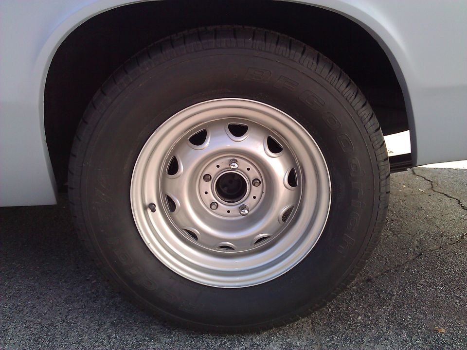 Close-up of a silver steel wheel with a black tire