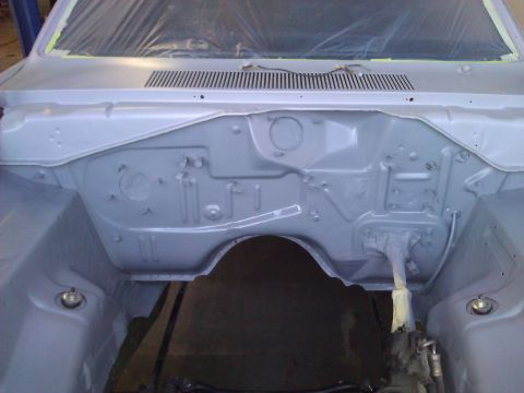 1971 Dodge Dart - The engine bay of a car is shown, covered in primer and ready for further work.