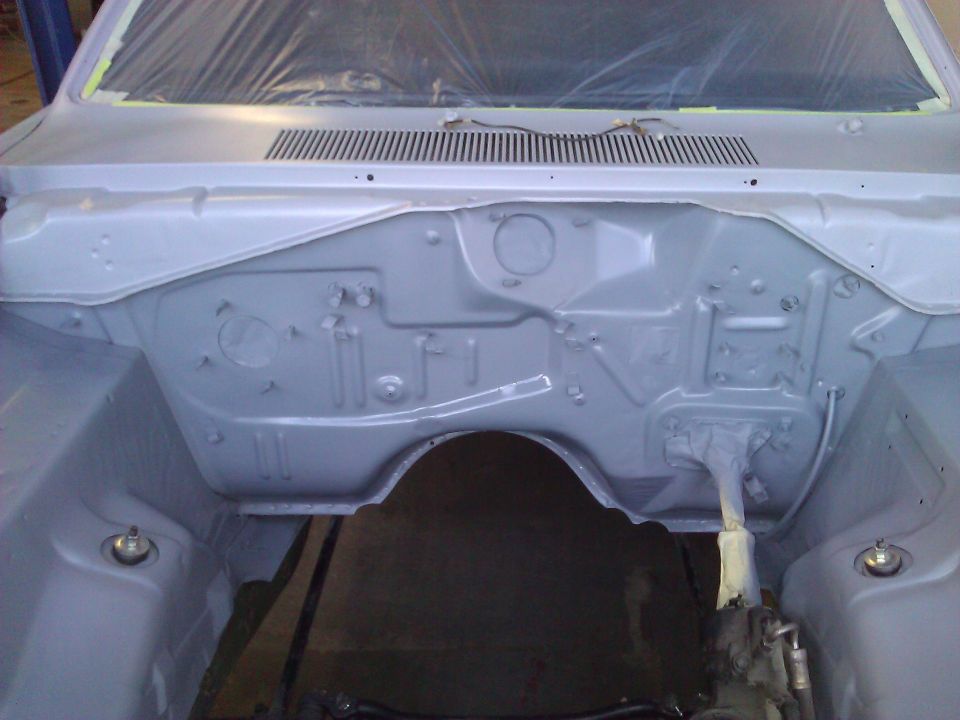 car's engine bay, appears to be prepped for paint, windshield covered