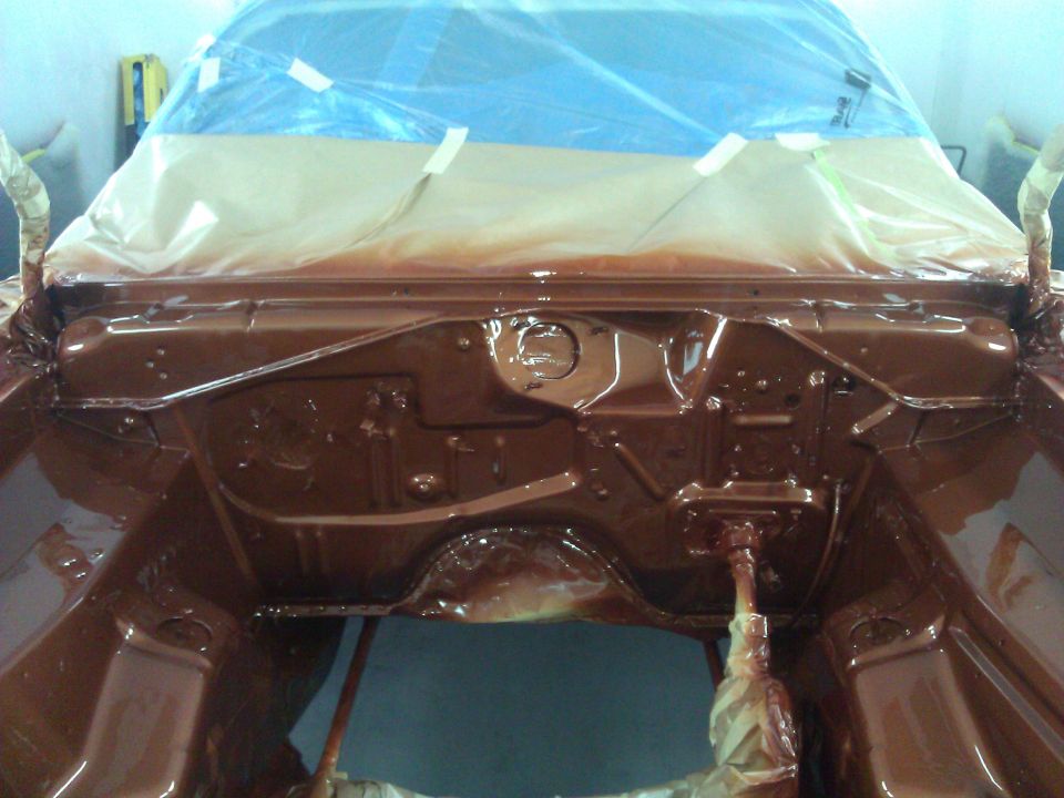 Car engine bay covered in plastic and tape, freshly painted brown