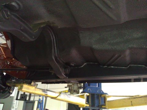 1971 Dodge Dart - The undercarriage of a vehicle is shown while it is raised on a hydraulic lift for inspection.