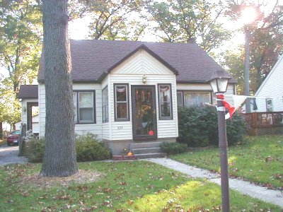 1997 Ford Taurus - A residential house with a tree and a street lamp in front.