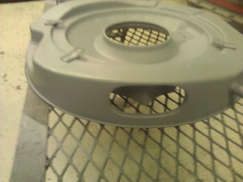 Gray air cleaner housing with a mesh grate visible through openings