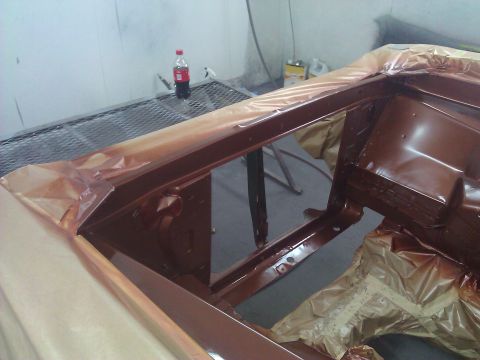 1971 Dodge Dart - The frame of a vehicle is being painted brown, with masking tape protecting surrounding areas.