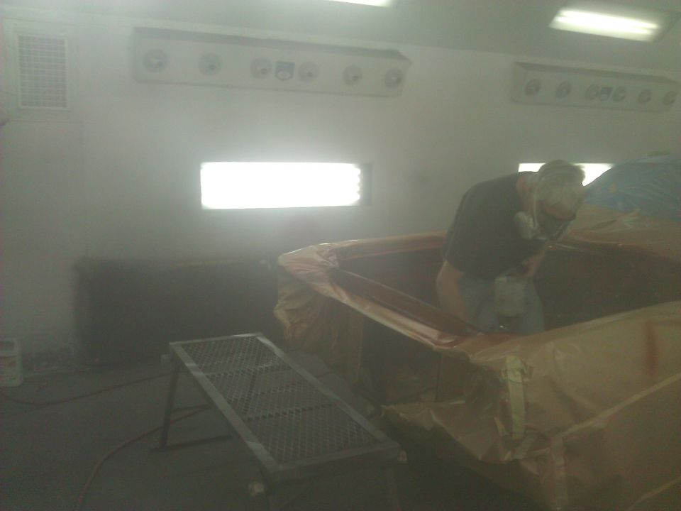 Person in spray booth painting car interior